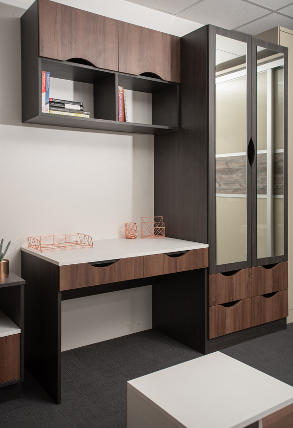 A bedroom or study fitted with chestnut wood effect cabinets